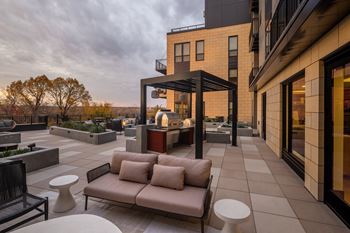 A patio with a couch and a table with a glass top.